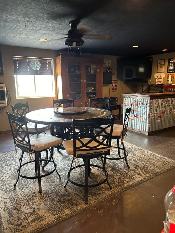 dining space featuring ceiling fan, concrete flooring, and a textured ceiling