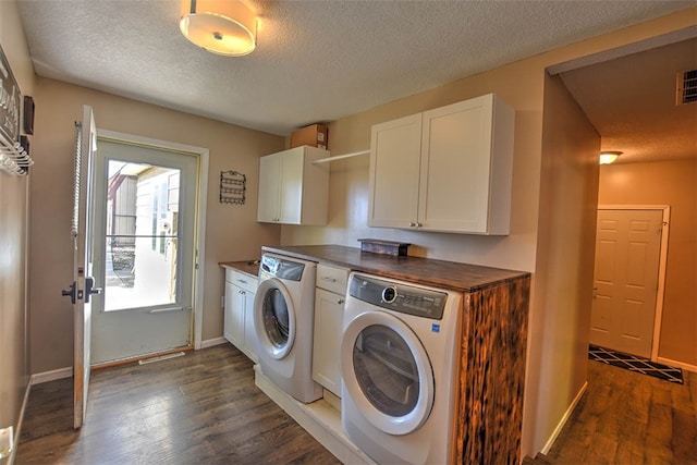 washroom with a textured ceiling, cabinets, dark hardwood / wood-style floors, and independent washer and dryer