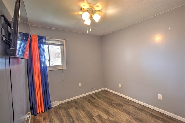 empty room with ceiling fan and dark wood-type flooring