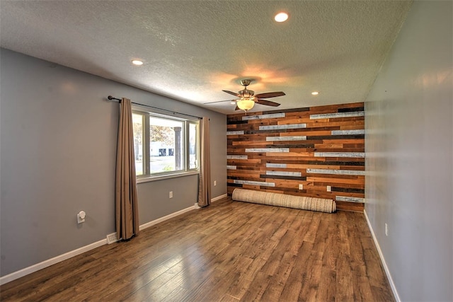 spare room featuring ceiling fan, dark hardwood / wood-style floors, and a textured ceiling