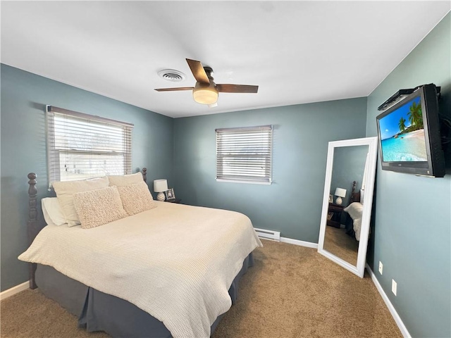 carpeted bedroom with a baseboard heating unit, baseboards, multiple windows, and visible vents