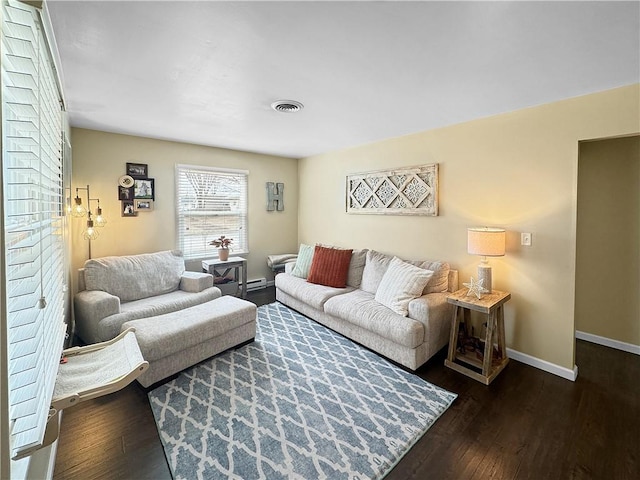 living room featuring wood finished floors, visible vents, and baseboards