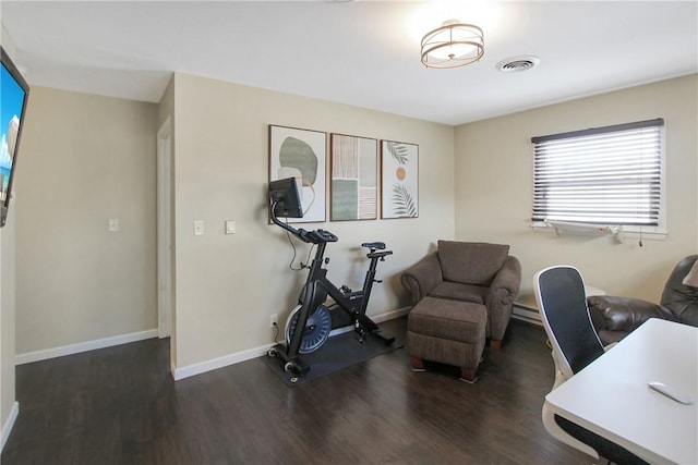 home office featuring baseboard heating, wood finished floors, visible vents, and baseboards