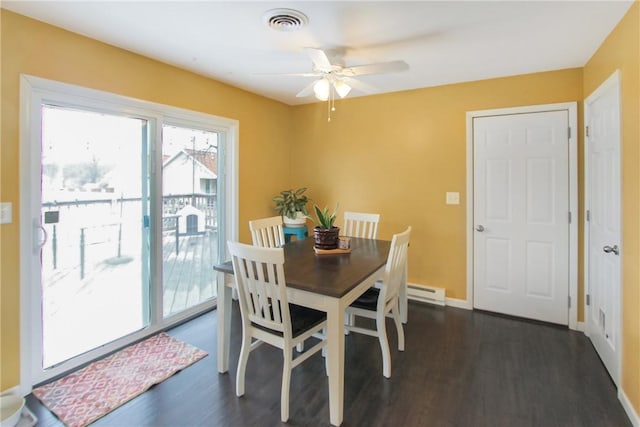 dining space featuring dark wood finished floors, visible vents, a baseboard heating unit, ceiling fan, and baseboards