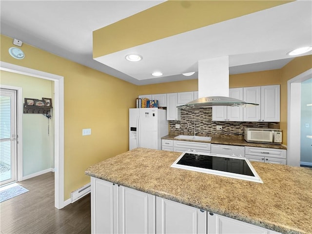 kitchen featuring white appliances, tasteful backsplash, island range hood, a baseboard radiator, and a sink