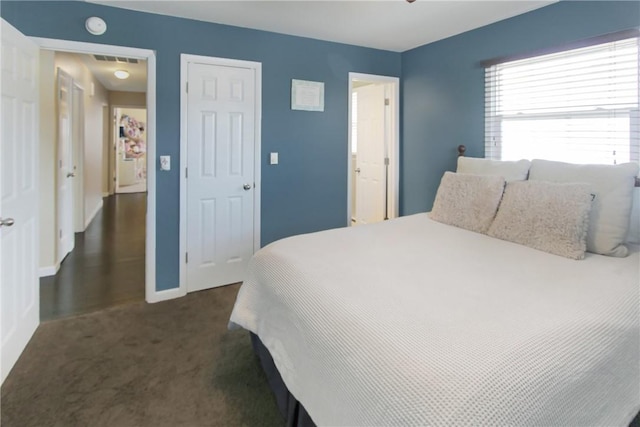 bedroom with visible vents, dark carpet, and baseboards