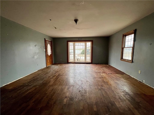 empty room with hardwood / wood-style flooring and a healthy amount of sunlight