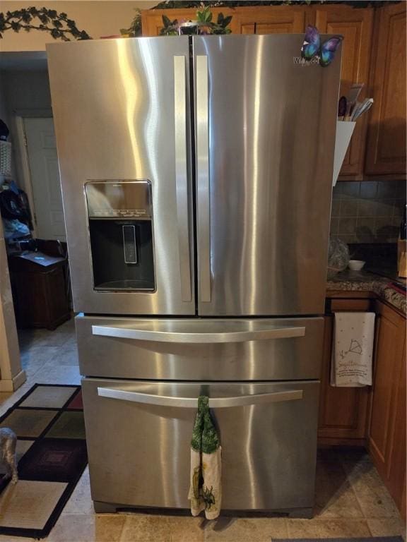 3254 Vista Dr, Danville, IL 61832 - detailed view of stainless steel fridge with ice dispenser, dark countertops, brown cabinetry, and tasteful backsplash