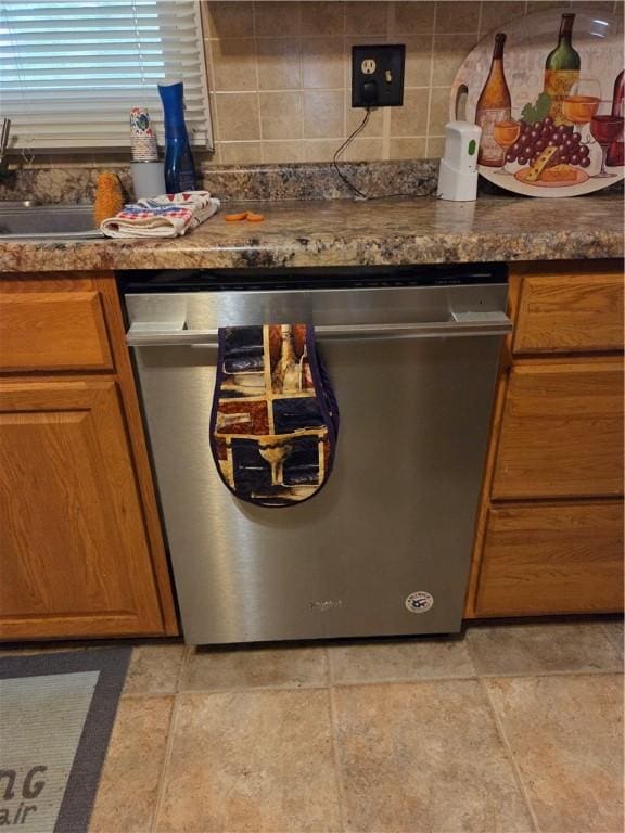 3254 Vista Dr, Danville, IL 61832 - kitchen with stainless steel dishwasher, brown cabinetry, and backsplash