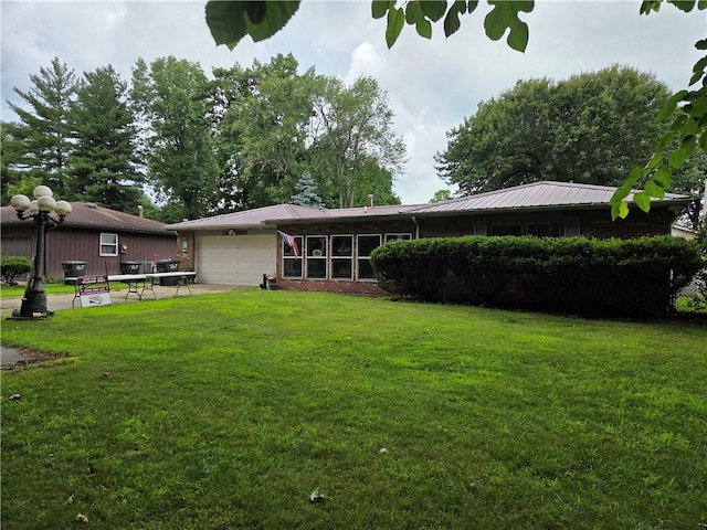 3254 Vista Dr, Danville, IL 61832 - rear view of property featuring a garage, a yard, and brick siding