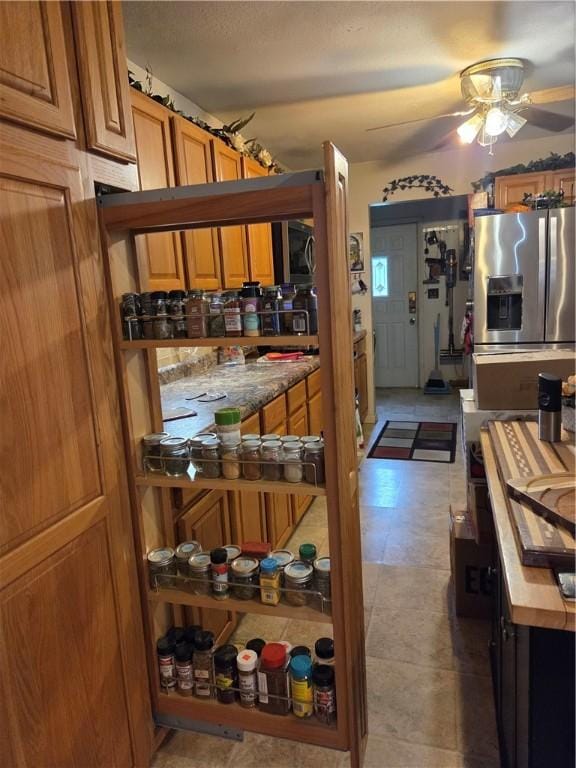 3254 Vista Dr, Danville, IL 61832 - kitchen with stainless steel fridge, ceiling fan, and brown cabinetry