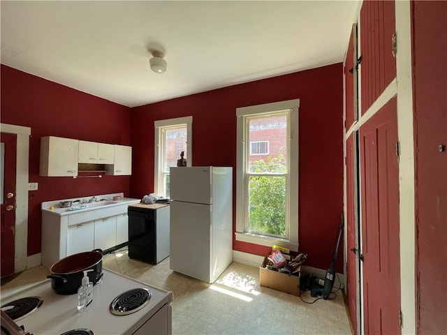 303 6th St, Charleston, IL 61920 - kitchen featuring white appliances, a wealth of natural light, and white cabinets