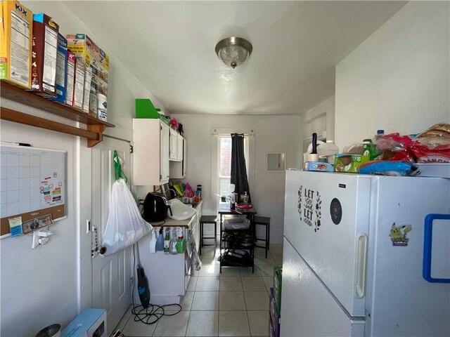 303 6th St, Charleston, IL 61920 - kitchen with white cabinetry, light tile patterned floors, and white fridge