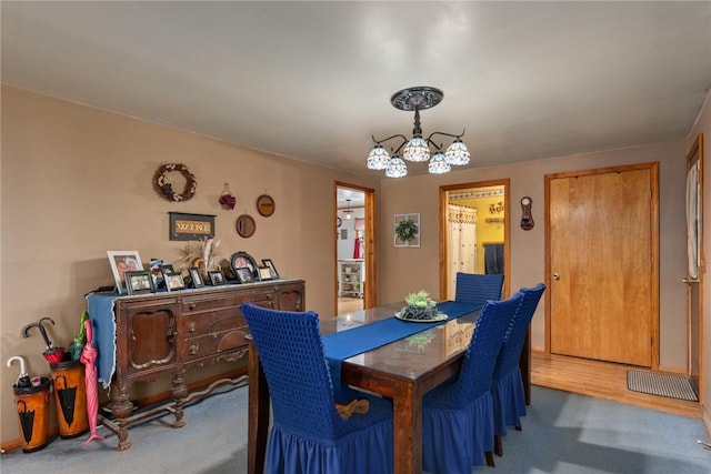 dining room featuring carpet flooring and a notable chandelier