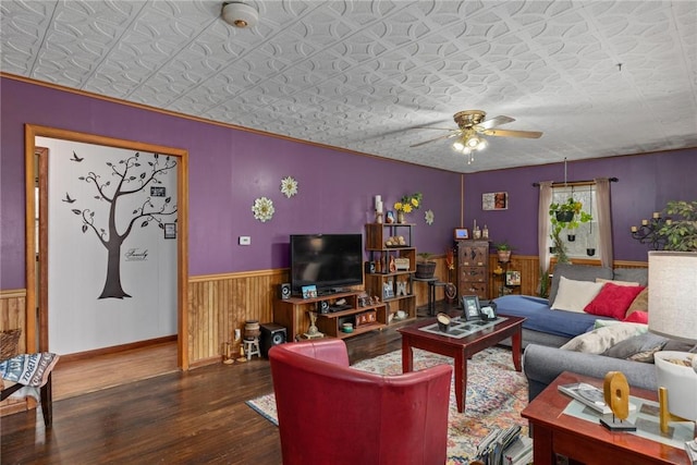 living room with wooden walls, ceiling fan, and dark hardwood / wood-style floors