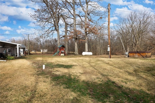 view of yard featuring a hot tub and a playground