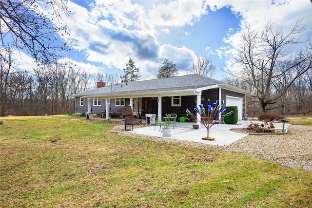 back of house featuring a yard, a garage, and a patio area