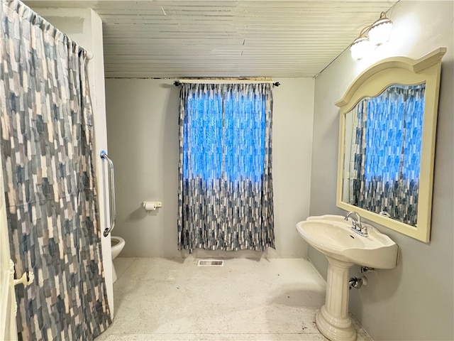 bathroom with toilet and concrete flooring