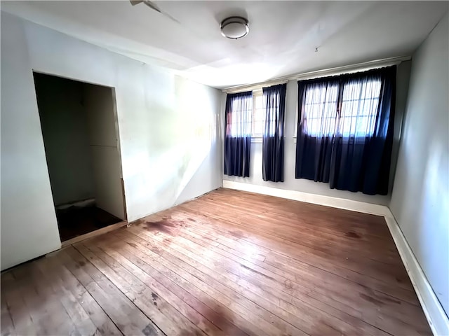 unfurnished room with hardwood / wood-style flooring