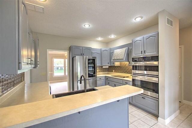 kitchen with stainless steel appliances, visible vents, a sink, and gray cabinets