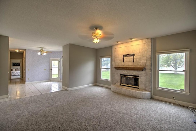 unfurnished living room featuring a fireplace, carpet flooring, a ceiling fan, and baseboards