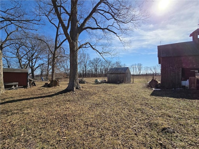 view of yard featuring a storage shed and an outbuilding