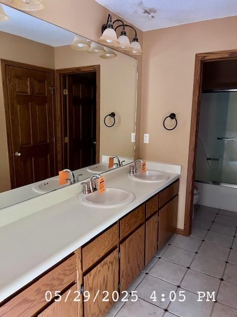 6680 John Dr, Mt Zion, IL 62549 - bathroom featuring double vanity, tile patterned flooring, and bath / shower combo with glass door