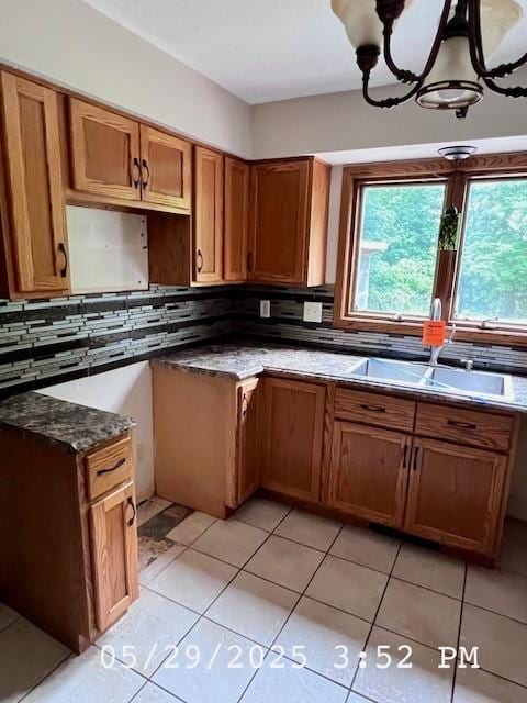 6680 John Dr, Mt Zion, IL 62549 - kitchen featuring decorative backsplash, brown cabinetry, and light tile patterned floors