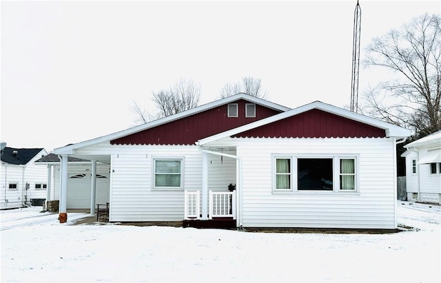 snow covered rear of property with a garage