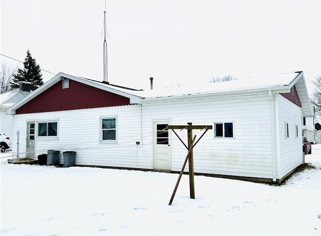 view of snow covered rear of property