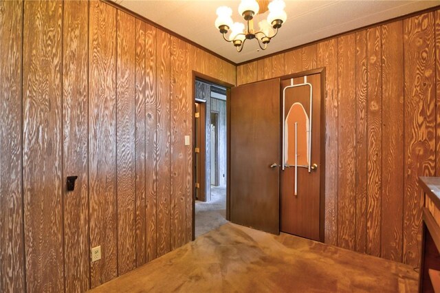 707 S Airport Rd, Decatur, IL 62521 - carpeted spare room featuring a chandelier, wooden walls, and ornamental molding