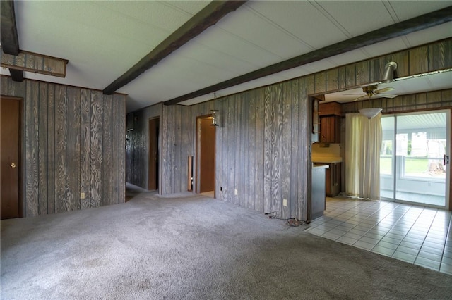 707 S Airport Rd, Decatur, IL 62521 - unfurnished living room with carpet floors, beam ceiling, wooden walls, and a ceiling fan