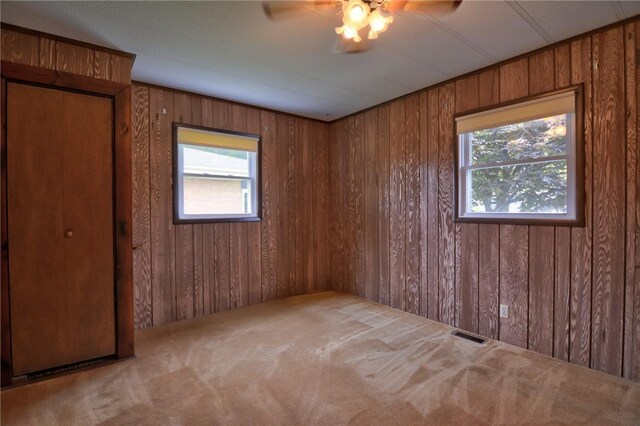 707 S Airport Rd, Decatur, IL 62521 - carpeted spare room featuring wooden walls, healthy amount of natural light, and a ceiling fan
