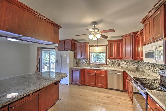 935 Woodland Dr, Mt Zion, IL 62549 - kitchen with stainless steel appliances, reddish brown cabinets, a ceiling fan, and backsplash