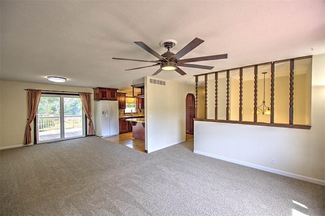 935 Woodland Dr, Mt Zion, IL 62549 - unfurnished living room with light colored carpet, ceiling fan, arched walkways, and a textured ceiling