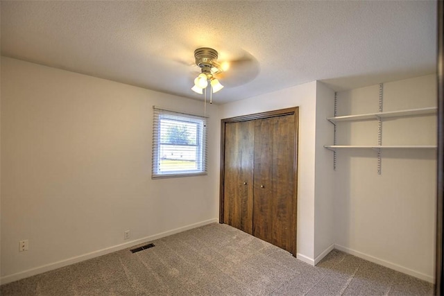935 Woodland Dr, Mt Zion, IL 62549 - unfurnished bedroom featuring carpet floors, a closet, a textured ceiling, and ceiling fan