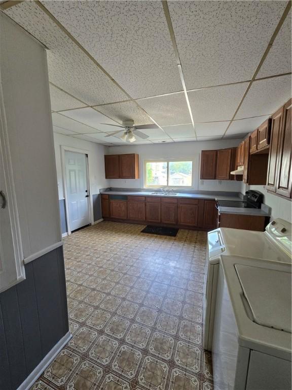 708 E Washington St, Clinton, IL 61727 - kitchen with washer and clothes dryer, a paneled ceiling, a ceiling fan, electric range oven, and under cabinet range hood