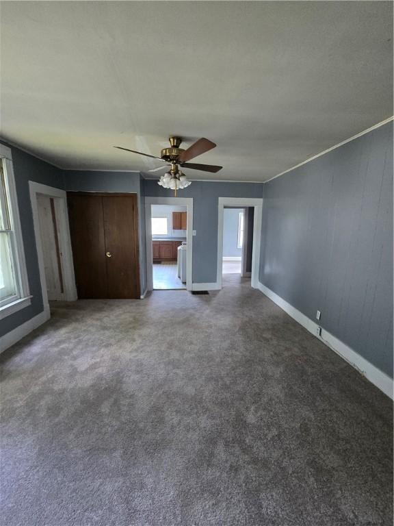 708 E Washington St, Clinton, IL 61727 - unfurnished living room with ceiling fan and carpet