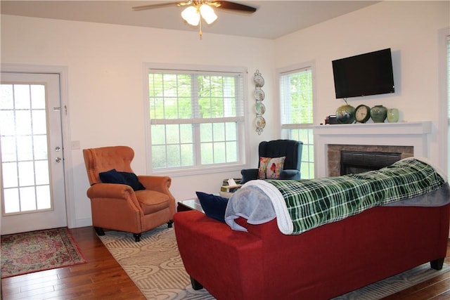 living area with ceiling fan, wood finished floors, and a fireplace