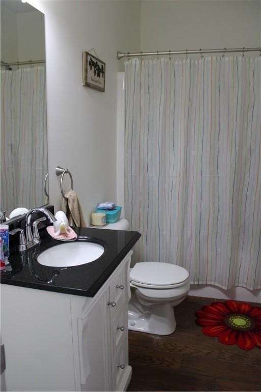 full bathroom featuring vanity, toilet, and wood finished floors