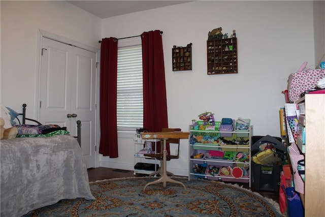bedroom featuring wood finished floors, a closet, and baseboards