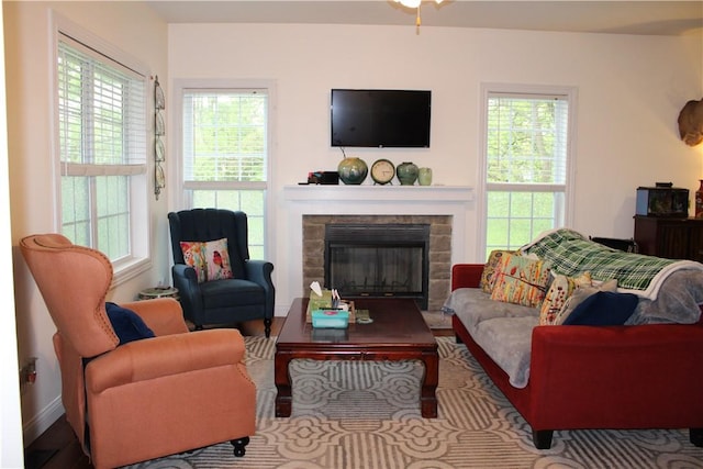 living area featuring a fireplace, wood finished floors, and baseboards