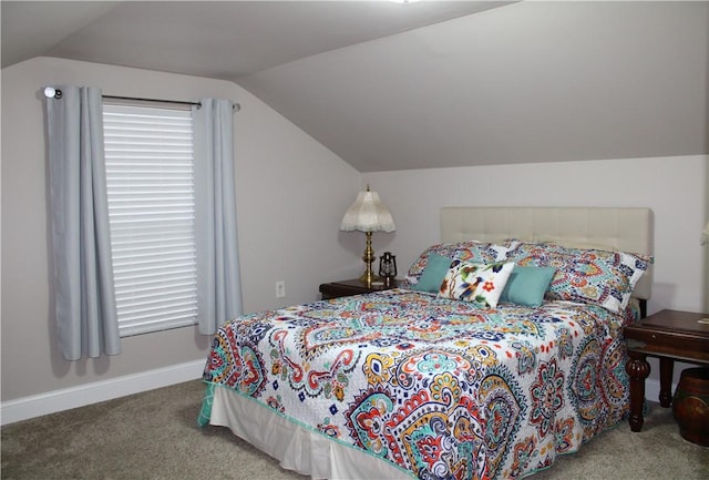 carpeted bedroom with vaulted ceiling and baseboards