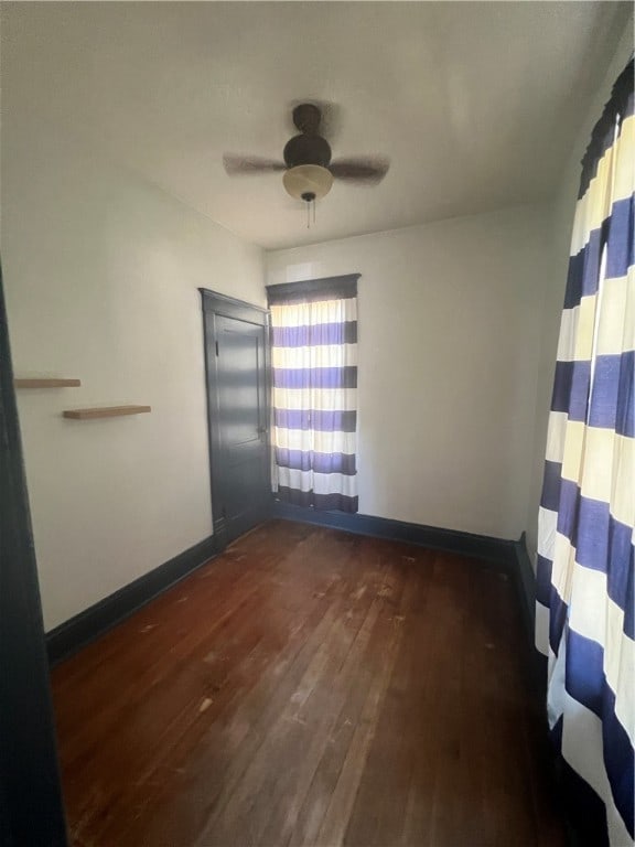 unfurnished room with dark hardwood / wood-style floors, a healthy amount of sunlight, and ceiling fan