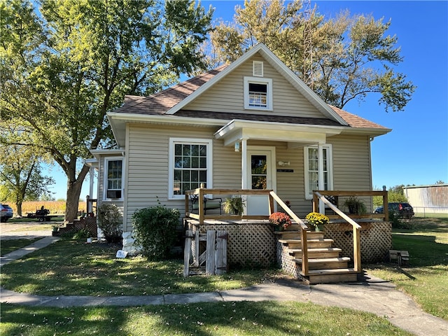 bungalow-style home with a front yard and covered porch