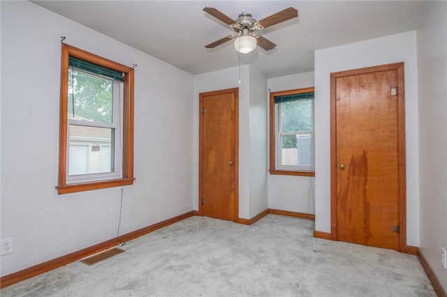 820 Oklahoma Ave, Mattoon, IL 61938 - unfurnished bedroom with carpet flooring, multiple windows, and a ceiling fan