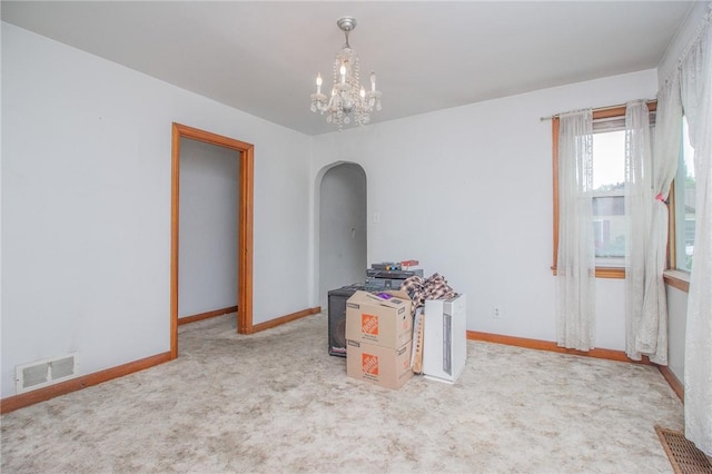 820 Oklahoma Ave, Mattoon, IL 61938 - unfurnished room featuring arched walkways, a chandelier, and carpet flooring