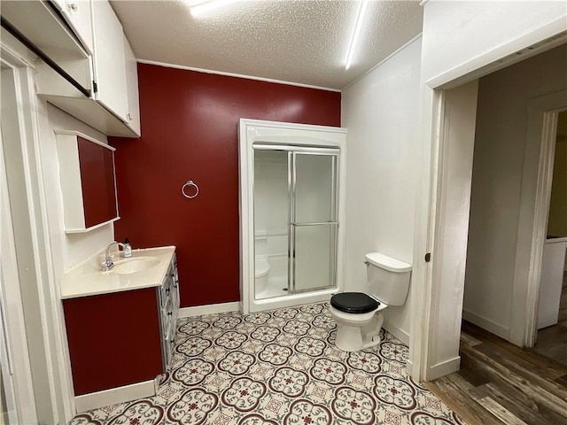601 S Maple St, Effingham, IL 62401 - full bathroom with toilet, vanity, a shower stall, a textured ceiling, and baseboards