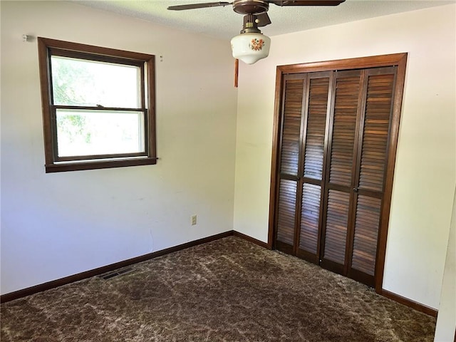 300 W Alabama Ave, Casey, IL 62420 - unfurnished bedroom featuring carpet, a closet, baseboards, and ceiling fan