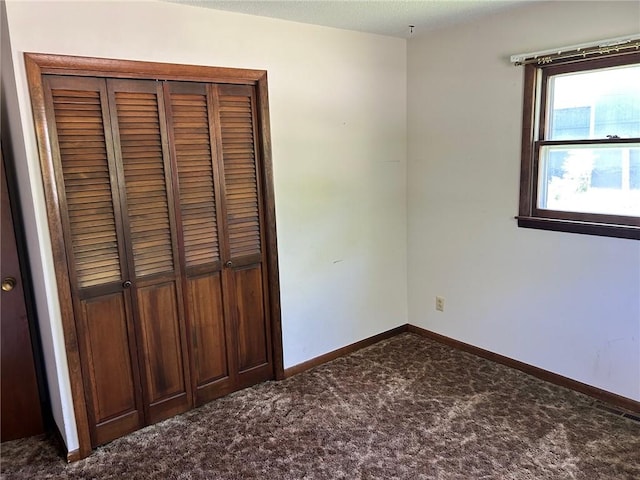 300 W Alabama Ave, Casey, IL 62420 - unfurnished bedroom with dark carpet, a closet, and baseboards